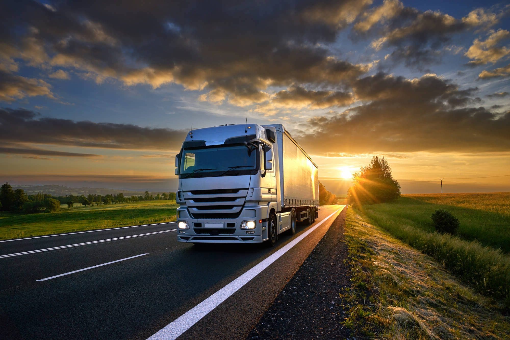 Truck Works curtainsider on a UK road at sunrise